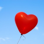 Red heart-shaped ballon with blue sky